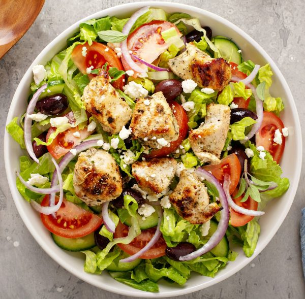 Greek salad with vinaigrette dressing topped with grilled chicken